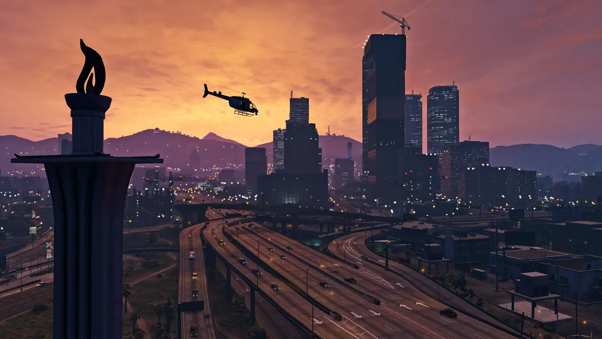 Downtown Los Santos skyline at sunset with a helicopter over the freeway in GTA V