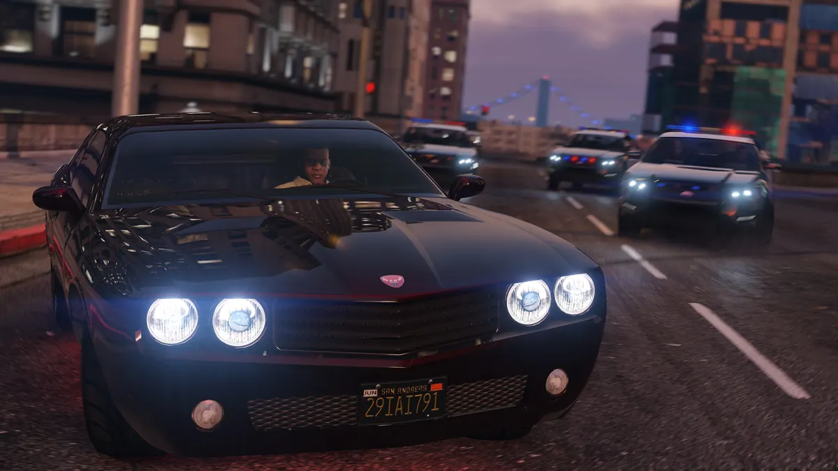 Black muscle car with police cars in pursuit on a city street at night in GTA V