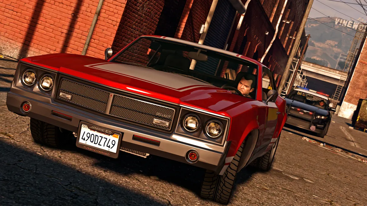 Red classic car parked on a brick-lined Vinewood street in GTA V