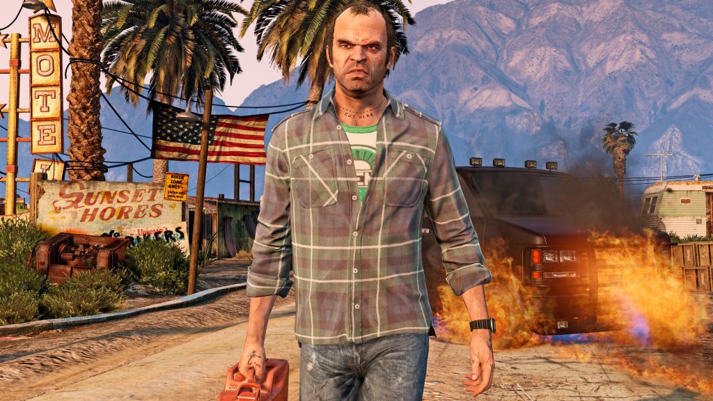 A bearded man in a dirty T-shirt outside a desert trailer