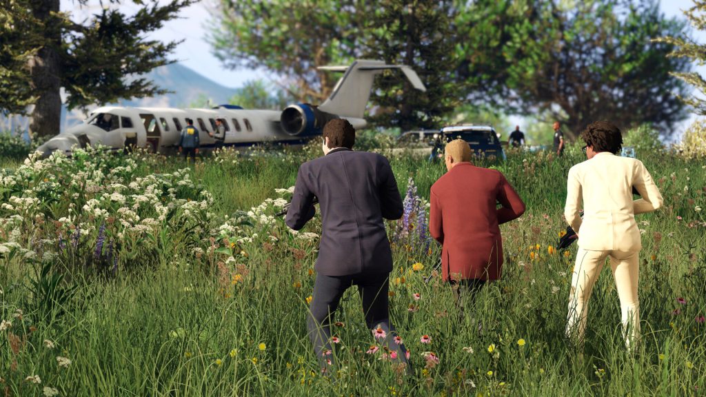 Michael, Franklin and Trevor walking through tall grass towards a crashed jet